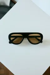 Lentes de sol con armazón de policarbonato color marrón traslúcido y diseño envolvente de una sola pieza.