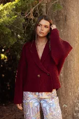 Saco de punto acanalado color bordó, con solapas anchas, cierre frontal cruzado con dos botones y mangas largas de corte holgado.
