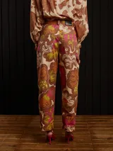 Pantalón de gabardina color marrón con estampado floral, corte carrot fit, tiro medio, estilo carpintero y detalles de botón de metal personalizado y parche trasero personalizado.