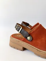 Zueco de cuero color ladrillo con correa trasera ajustable color marrón oscuro y suela track color marrón claro.