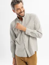 Camisa de corte regular confeccionada en tejido oxford, color azul claro. Presenta cuello con botones, cierre frontal abotonado, mangas largas con puños y un bolsillo frontal en el pecho.