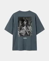 Remera oversize gris oscuro con corte holgado, mangas cortas y estampa trasera en blanco y negro con forma de estampilla que muestra a una persona con un gato y el texto 'Kaboa Industries'.
