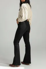 Pantalón de jean negro de tiro alto, con corte ajustado en la parte superior y botamanga ligeramente acampanada.