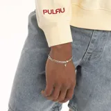 Buzo de algodón color crema, de corte holgado, con cuello redondo ribeteado en azul y logo bordado en el pecho.