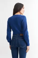 Cárdigan color borgoña de tejido de punto con textura acanalada, escote en V, cierre frontal con botones y mangas largas abullonadas.