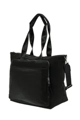 Bolso tipo shopper de color crudo, con asas de mano negras y detalle de agarre en color beige claro. Presenta un bolsillo frontal con cierre y cierres en el compartimento principal. Incluye correa ajustable para llevar al hombro.