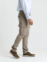 Pantalón cargo de algodón sarga con elastano, color verde militar. Presenta bolsillos laterales con fuelle, bolsillos traseros con tapa y botón, y costuras reforzadas en las rodillas.