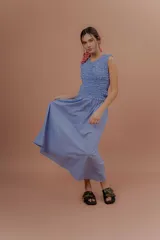 Vestido midi sin mangas de color azul con estampado a cuadros vichy. Presenta la parte superior completamente elastizada y ajustada con efecto fruncido, y falda amplia y suelta.