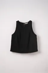 Blusa sin mangas de corte recto y cuello redondo, confeccionada en tejido airflow con textura sutil. Presenta un cierre posterior con abertura y pequeñas aberturas laterales en el ruedo.