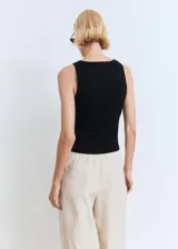 Top sin mangas de tejido de punto fino, con cuello en pico y detalle de lazo frontal en el escote. Presenta un diseño entallado con tirantes anchos.