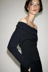 Jersey de punto con cuello fluido, manga larga y detalle de botones en la parte frontal.