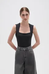 Body de poliamida al cuerpo con breteles anchos y escote cuadrado. Cuenta con cierre de broches en la parte inferior.