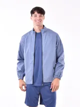 Campera deportiva azul claro, estilo cortavientos, con cuello mao y cierre frontal. Presenta puños y cintura elásticos.