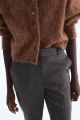 Pantalón de vestir tobillero, color gris oscuro, con patrón Príncipe de Gales (cuadros pequeños). Presenta cintura estándar con elástico oculto, cierre frontal con corchete oculto, bolsillos laterales y bolsillos traseros decorativos.