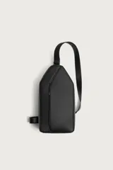 Bandolera vertical de diseño minimalista en color negro, con acabado texturizado. Cuenta con compartimento principal con cierre de cremallera, bolsillo frontal con cierre y asa de hombro ajustable.