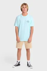 Remera Billabong de manga corta color celeste, con estampado gráfico en la espalda con diseño de una quilla de tabla de surf, un sol y la leyenda "Feeling Free Since Nineteen Seventy Three".