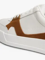Zapatillas de corte bajo Tommy Hilfiger con diseño inspirado en el tenis, confeccionadas en piel napa blanca con paneles laterales de gamuza en color marrón. Presentan cierre con cordones, suela de goma y detalles de logo en bajo relieve.