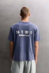 Camiseta de corte regular fit confeccionada en algodón, con cuello redondo y mangas cortas, presentando un acabado de color azul con efecto lavado.