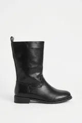 Botas de caña alta color negro, confeccionadas en cuero vegano, de diseño clásico y cómodo con suela plana y presilla en el talón.