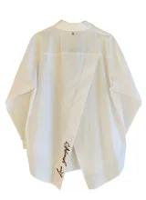 Camisa blanca de popelina con manga larga, cierre con botones delanteros y bordado en contraste en la espalda con la frase 'Love yourself'.