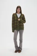 Cardigan de punto con diseño de cuadros, cuello en V y cierre frontal con botones. Presenta un corte holgado y mangas largas.
