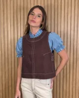 Chaleco marrón de denim con pespuntes en contraste, cuello redondo y cierre frontal con botones.