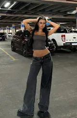 Pantalón de jean estilo wide leg con tiro bajo, en color negro lavado. Presenta un corte recto y holgado, con cierre frontal y bolsillos clásicos.