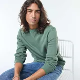 Buzo de felpa perchada color verde con cuello redondo y mangas largas.