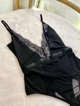 Body entallado confeccionado en lycra, microtul y encaje. Presenta breteles regulables, escote en V con detalle de encaje y paneles de microtul en la cintura. Diseño con cierre de gancho en la cintura.