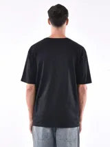 Remera de manga corta color beige, con corte oversize y cuello redondo.