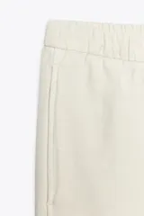Pantalón jogger de la colección Zara Woman, color gris claro, confeccionado en hilatura con algodón y lyocell. Presenta tiro medio, cintura elástica ajustable con cordones, bolsillos laterales ocultos en costura y pierna ancha.