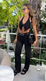 Pantalón negro de lino de corte ancho con aberturas en el ruedo y cintura con cinturón.