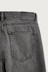 Pantalón de jean corte slim fit, color azul oscuro, con diseño de cinco bolsillos, tiro medio y cierre frontal con cremallera y botón.