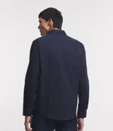 Camisa de vestir blanca de algodón con textura maquinetada, cuello camisero y mangas largas.