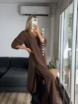 Vestido largo negro de tela de Cey, con escote en V, mangas largas abullonadas, tajo lateral con detalle de encaje y ruedo con encaje.