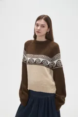 Sweater de tejido de punto con diseño jacquard, cuello redondo y mangas largas. Presenta una combinación de bloques de color azul marino y celeste con un patrón geométrico en la parte superior.