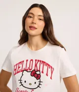 Remera blanca de algodón con cuello redondo y manga corta. Presenta un estampado grande con la cabeza de Hello Kitty en el centro, rodeada por el texto 'HELLO KITTY' en letras rojas con efecto desgastado y la frase 'Sporty' debajo.