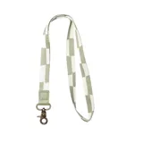 Llavero para el cuello con cinta de tela a cuadros color verde y blanco, con mosquetón metálico color bronce y aplique de cuero sintético verde con logo grabado.