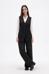 Chaleco largo de corte sastrero en color negro, con escote en V, cierre frontal de botones y bolsillos laterales simulados.