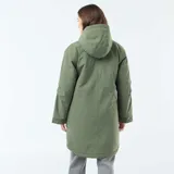 Parka larga de color verde con capucha ajustable mediante cordones y forro interior de efecto borreguito. Presenta un cierre frontal de cremallera oculto por una solapa con botones a presión y dos bolsillos grandes de parche con solapa en el frente.