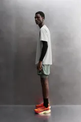 Camiseta de entrenamiento de ajuste regular, color verde oliva, confeccionada en tejido técnico ligero y elástico con estructura. Presenta cuello redondo, manga corta y costuras planas.