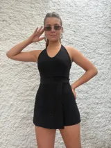 Mono corto negro con lurex, escote halter y espalda descubierta.