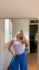 Top sin mangas de cuello redondo, confeccionado en tela texturizada y elastizada, con ajuste al cuerpo.