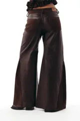 Pantalon de corte wide leg confeccionado en una combinación de cueros ovinos en tonos chocolate, incluyendo paneles de cuero liso, cuero desgastado y gamuza suave. Presenta diseño de cinco bolsillos y cierre frontal.