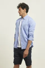 Camisa de manga larga color gris claro con textura, cuello abotonado y bolsillo en el pecho.