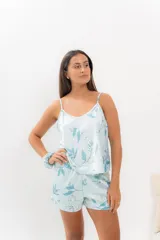 Pijama de seda estampada con diseño floral en tonos celestes y blancos. Incluye una musculosa con escote en V y espalda recta, y un short con elástico en la cintura.