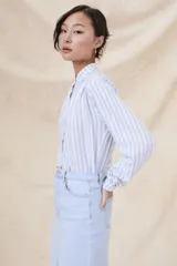 Camisa de manga larga con cuello mao y estampado a rayas verticales celestes y blancas.