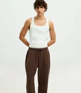 Pantalón jogger de pijama color negro, confeccionado en tejido de modal con mezcla de poliéster y elastano. Presenta cintura elástica con cordón de ajuste, bolsillos laterales y puños ajustados en el ruedo.