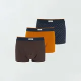 Pack de tres bóxers de algodón para hombre, uno a rayas horizontales azul y marrón, uno liso color ladrillo y uno azul con estampado de puntos marrones. Todos tienen cintura elástica azul.