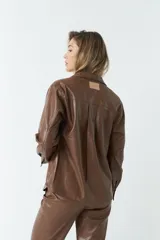 Sobrecamisa negra de efecto cuero con bolsillos frontales y botones a tono.